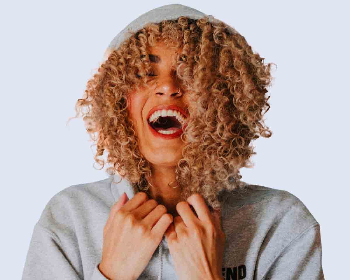 Promotional banner on Urbness home page showing up to 50% off discount and free shipping on all U.S. orders over $100.00, featuring a happy model in a grey hoodie, managed by Zizzle LLC.