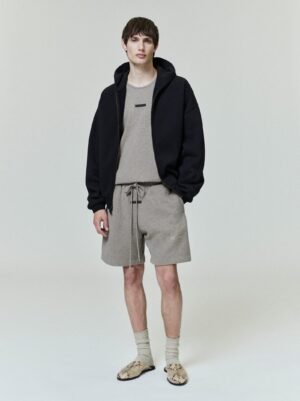 Detailed and lifestyle shots of the authentic 480gsm Black Essentials embossed logo zip-up hoodie, featuring premium heavyweight fleece construction, managed by Zizzle LLC.